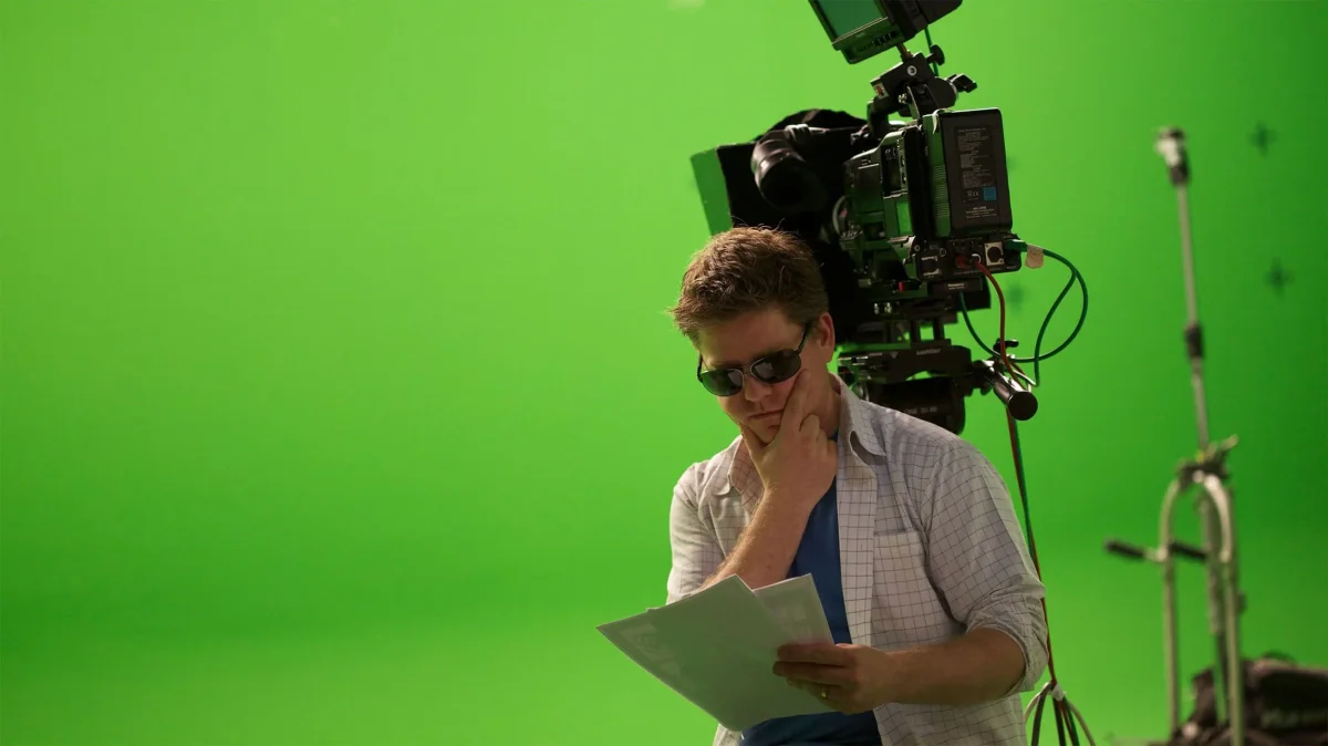 Bas leest een script op een green-screen set